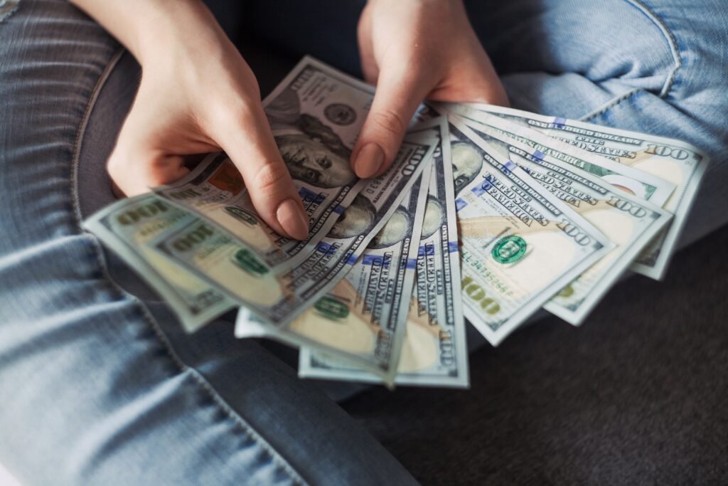 An investor who has achieved financial freedom counting a wand of US Dollar bills