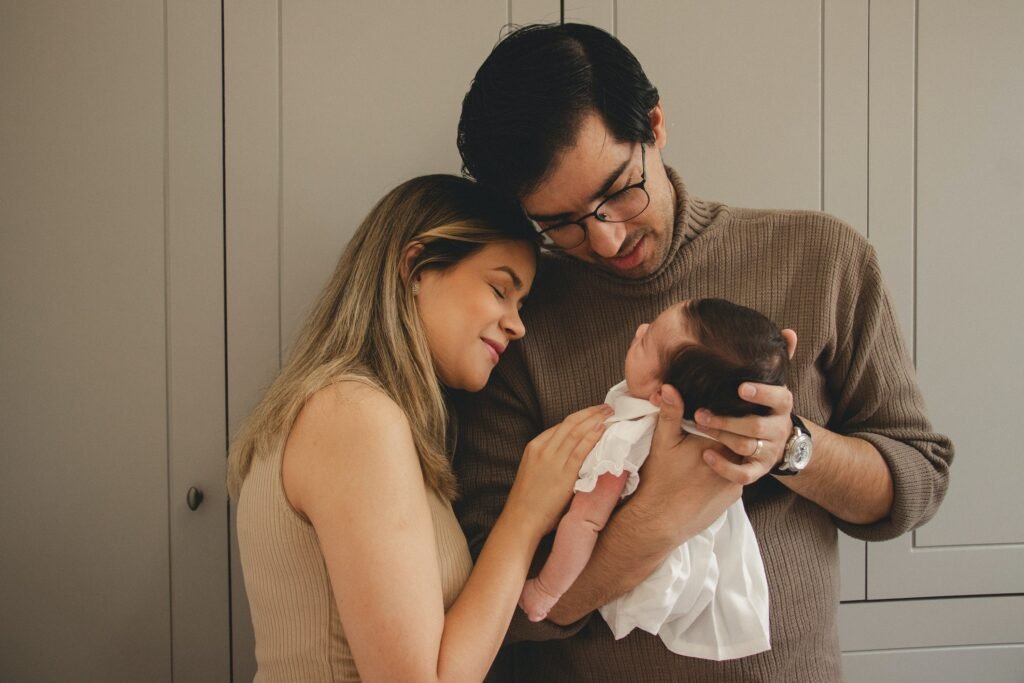 A Black couple happily admiring their baby as they enjoy parenthood