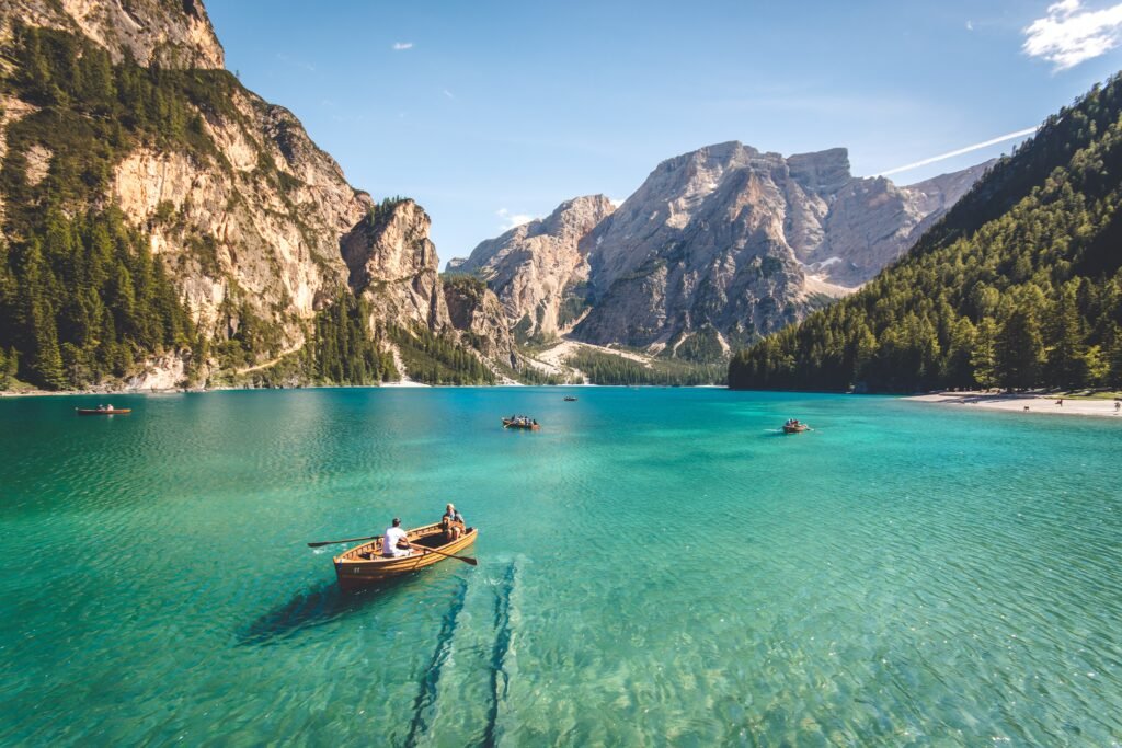 A man canoeing on a clear blue sea facing picturesque mountainous peaks as opportunity knocks for a wonderful adventure