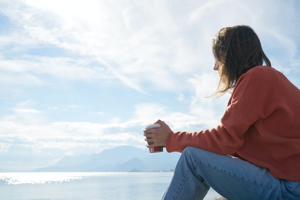 A lonely lady sitting besides a beach thinking how to navigate her recent marital breakdown
