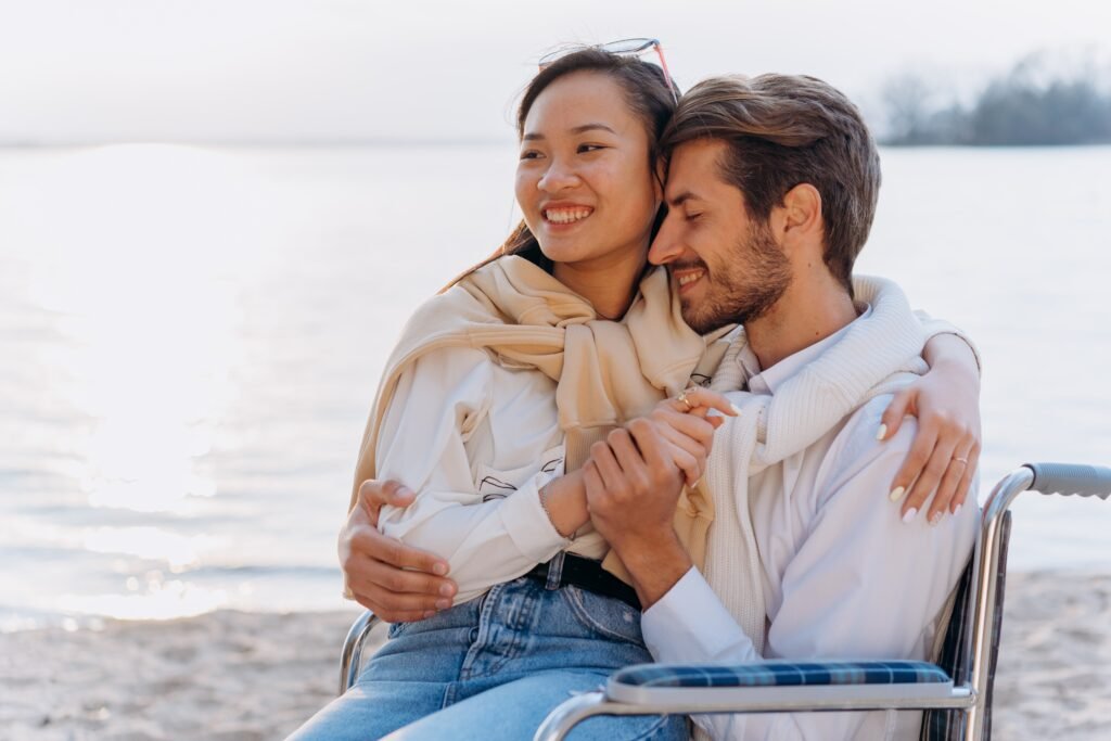 Happy couples holding hands while seated in the beach as sign of their commitment in marriage