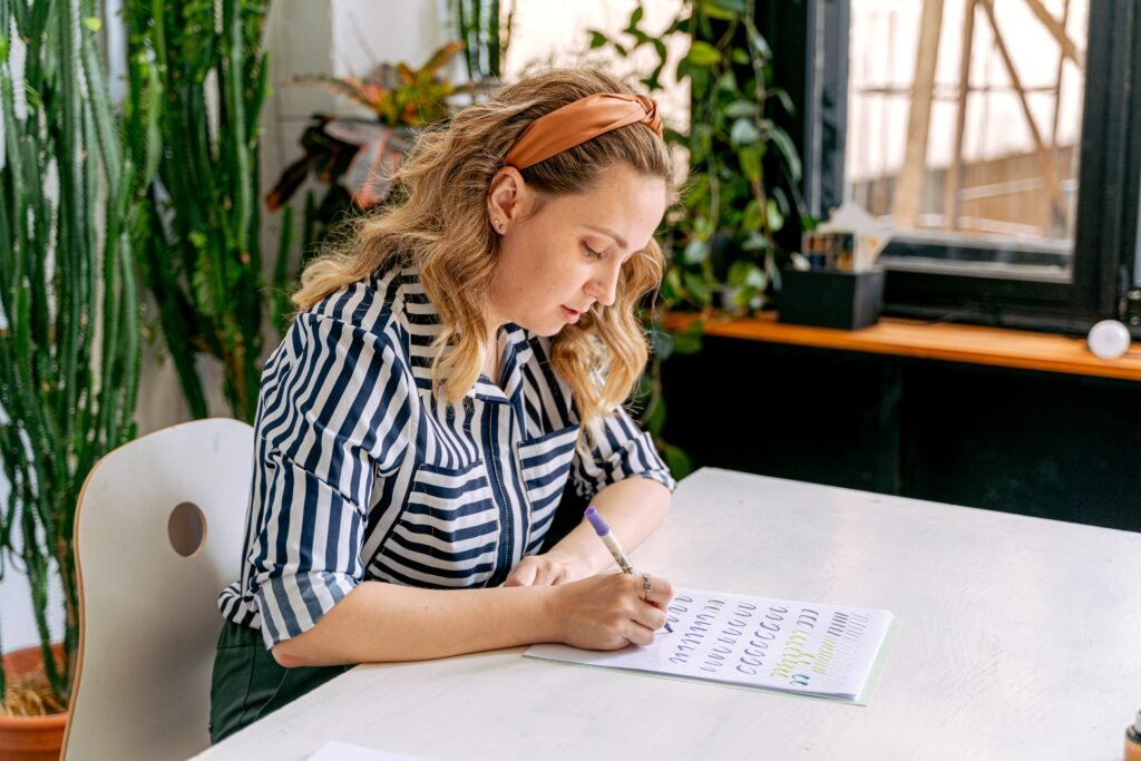 A wife is taking her self-care by journaling about her experiences during her break at work.