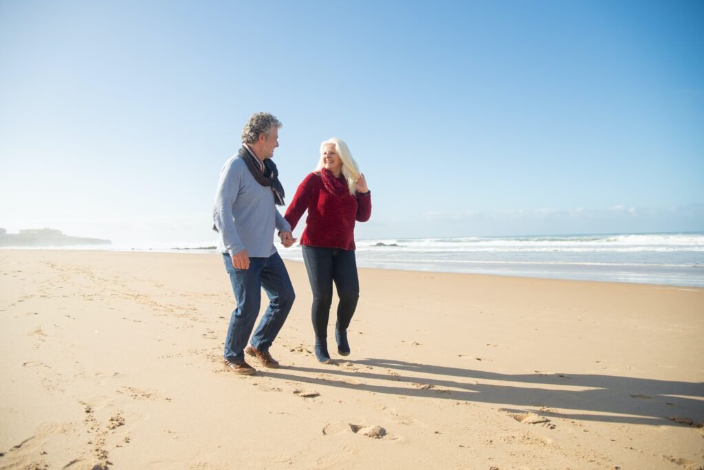 A couple strolling along the beach holding hands as a reflection of healthy boundaries in marriage