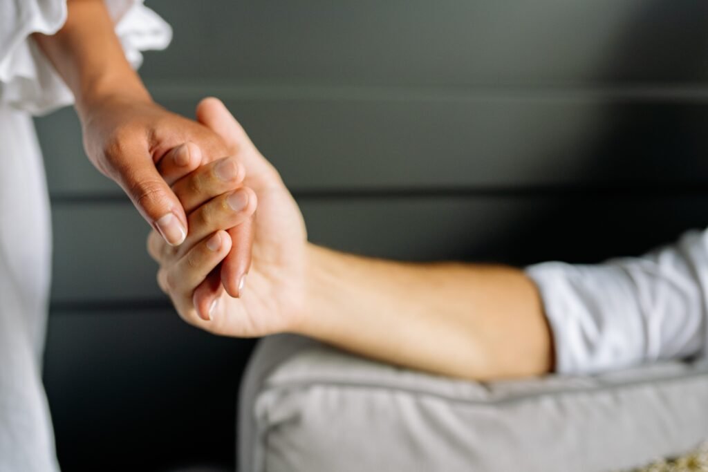 A couple holding hands in the bed after making amend following a quarrel