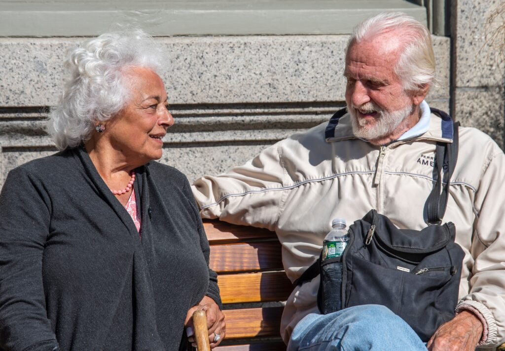 Elderly Black couple seated at a bench in long-term relationships