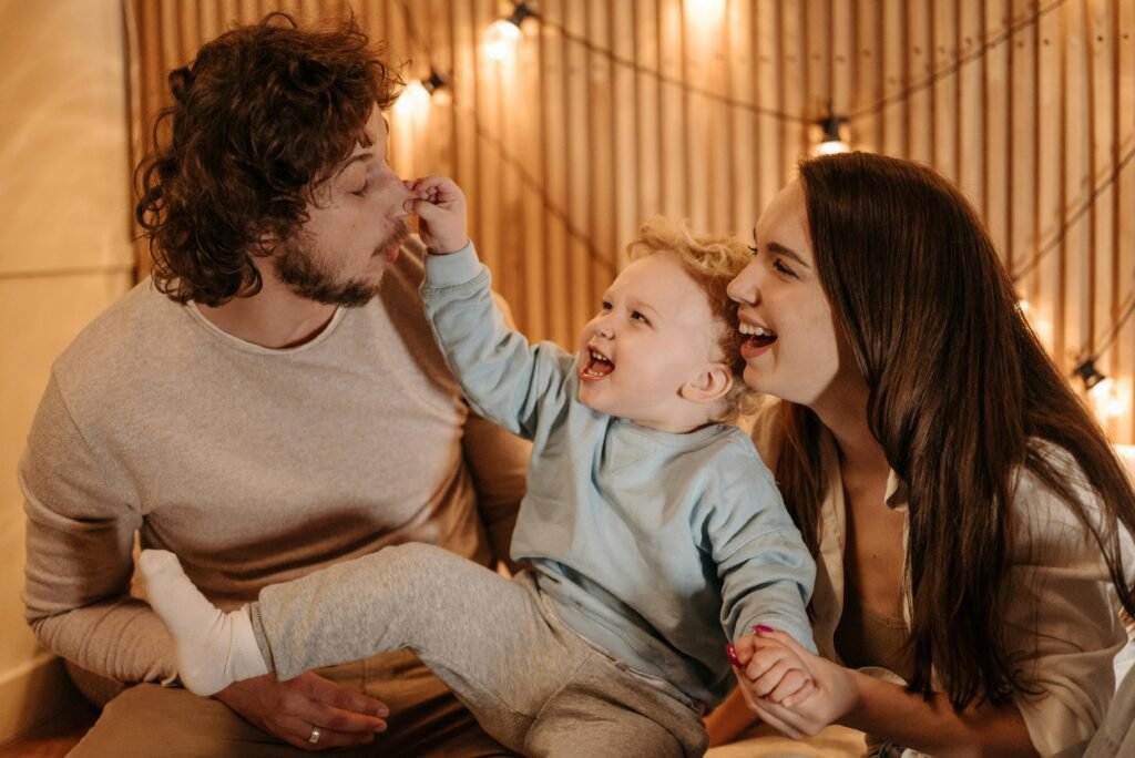 A couple holding their young son expressing the power of laughter