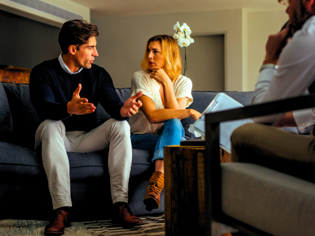 A couple discussing their marriage conflicts before a relationship coach.