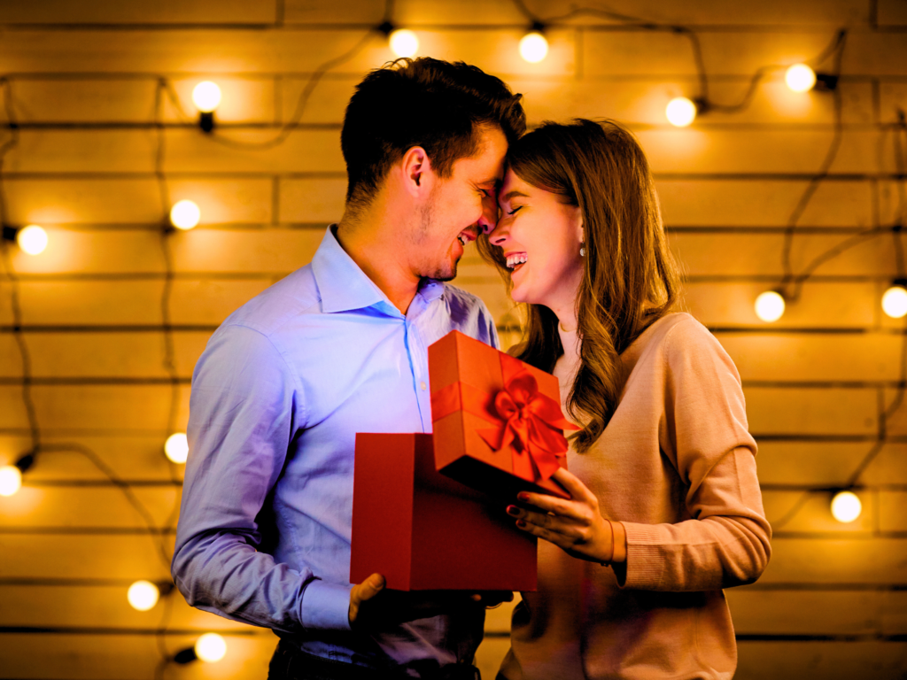 A husband hands his wife a beautiful gift to mark their wedding anniversary.