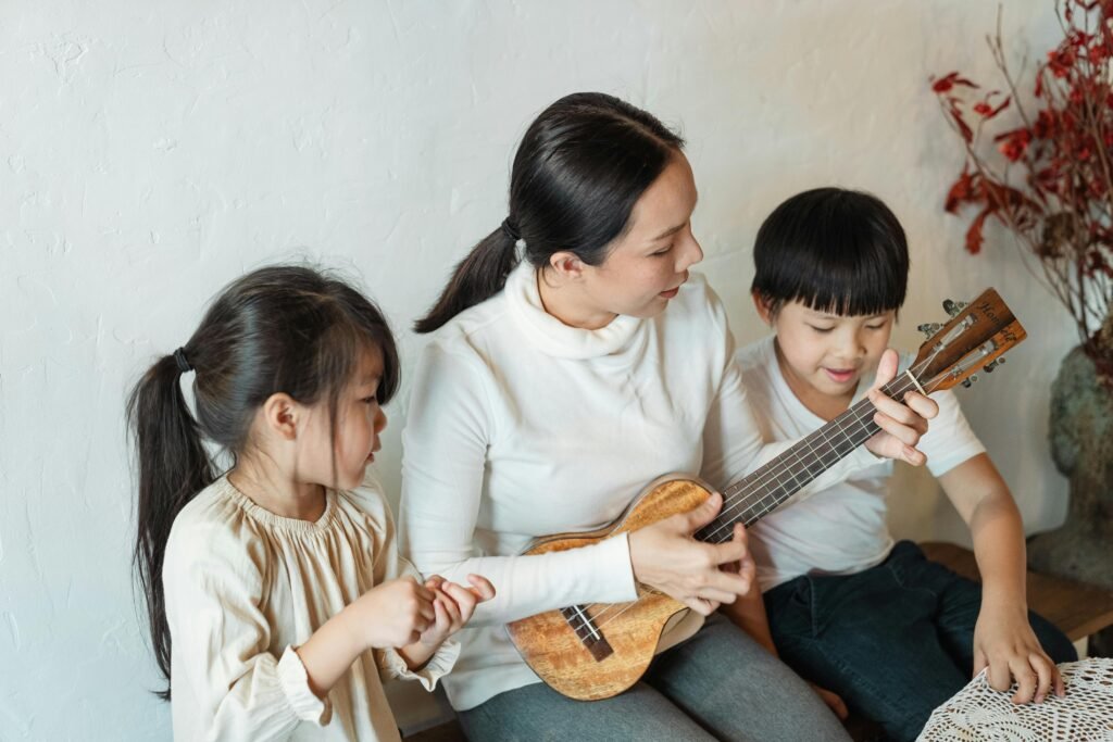 A mum playing Chinese guitar to her two children to celebrate the Chinese Year.
