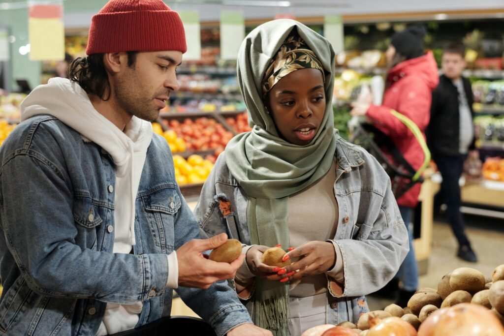 A multiracial couple shopping in the fruit market, heeding to advice from their relationship coach to "nurture your relationship"