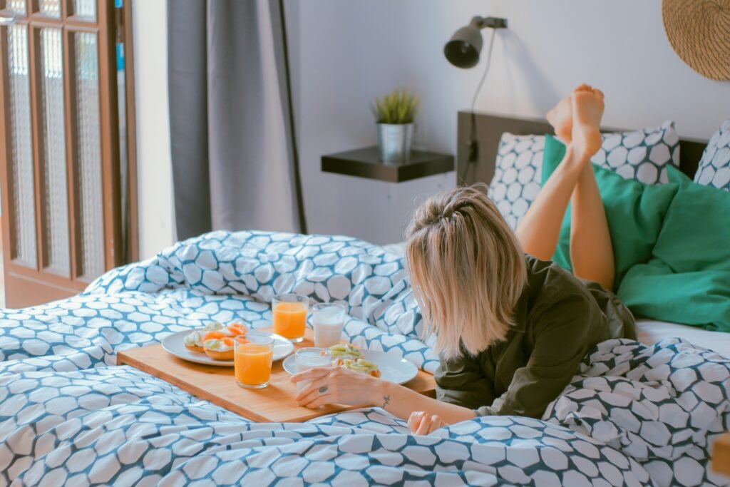 A lady enjoying breakfast while laying on the bed on her birthday while contemplating her self-discovery journey.